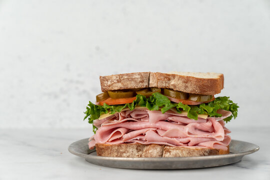 Deli sandwich with drink on a light surface