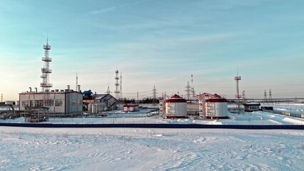 Drone flying over an oil and gas production facility in winter. The drone flies over the snow in...