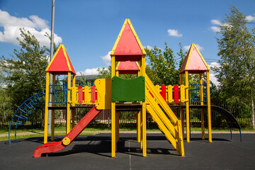 Fototapeta na wymiar Wooden slides made of natural red yellow wood on the playground on a bright sunny day. Playgrounds, sports, health entertainment.