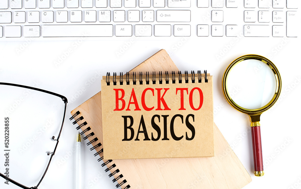 Poster back to basics text in the office notebook with keyboard, magnifier and glasses , business concept