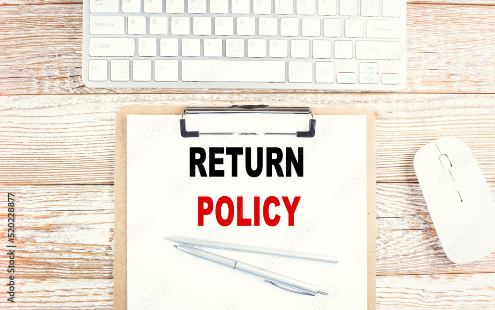 Poster return policy text on clipboard with keyboard on wooden background