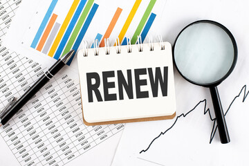 RENEW text on notebook on the graph background with pen and magnifier