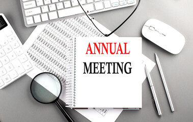 ANNUAL MEETING text on notepad on chart with keyboard and calculator on grey background