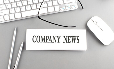 COMPANY NEWS text on paper with keyboard on grey background
