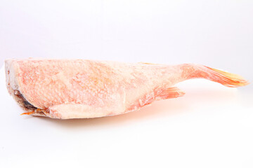 Frozen sea bass without a head. Frozen red fish Frost on the surface of the fish. Ice.