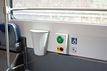 Train carriage, seats reserved for the disabled. USB charger and emergency button.
