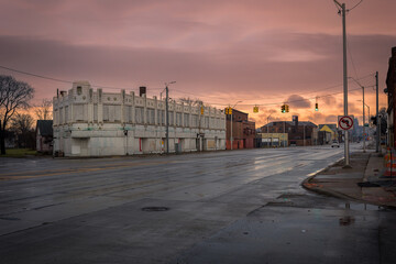 Looking down a wide avenue with abandoned buildings in urban Detroit with dramatic sky