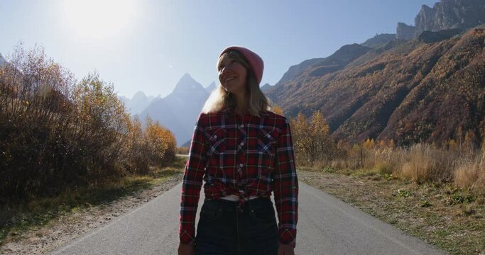 Woman enjoy in the autumnal mountains on road