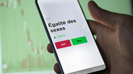 Un investisseur analyse un fonds etf égalité des sexes sur un graphique. Un téléphone affiche le cours de l'ETF Égalité des sexes