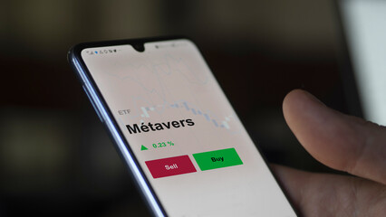 Un investisseur analyse un fonds etf métavers sur un graphique. Un téléphone affiche le cours de l'ETF Métavers