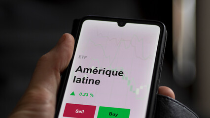 Un investisseur analyse un fonds etf amérique latine sur un graphique. Un téléphone affiche le cours de l'ETF. Texte en français francais Amérique latine