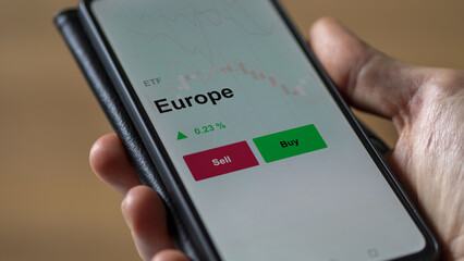 Un investisseur analyse un fonds etf europe sur un graphique. Un téléphone affiche le cours de l'ETF. Texte en français francais Europe