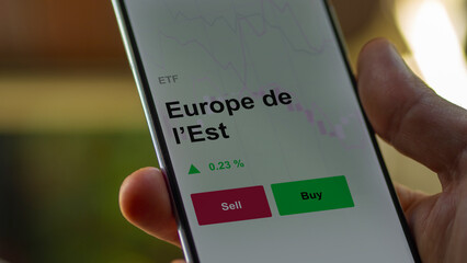 Un investisseur analyse un fonds etf europe de l’est sur un graphique. Un téléphone affiche le cours de l'ETF. Texte en français francais Europe de l’Est