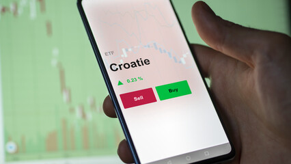 Un investisseur analyse un fonds etf croatie sur un graphique. Un téléphone affiche le cours de l'ETF. Texte en français francais Croatie