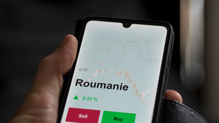 Un investisseur analyse un fonds etf roumanie sur un graphique. Un téléphone affiche le cours de l'ETF. Texte en français francais Roumanie