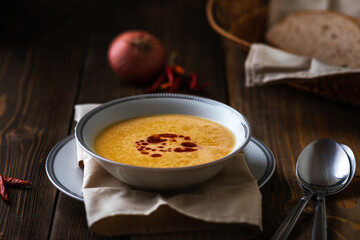 Turkish traditional lentil soup mercimek corbasi on dark wooden background.