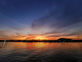 Naklejka premium Ocean sea with evening sunset and twilight cloud sky background reflect on water floor landscape in Thailand