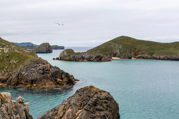 Northern Spain beach, beautiful sea, next to cliffs and rocks on the shore