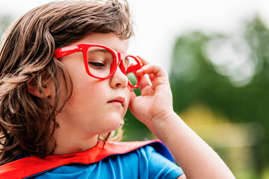 Little superhero adjusting stylish glasses