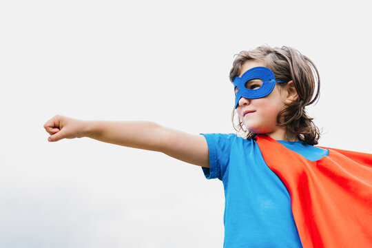 Excited girl in superhero costume in park