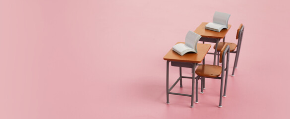 School desk with books on pink background