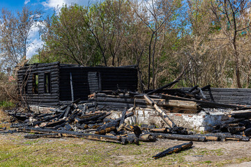 the remains of a burnt log house on the background of nature (Corrected)