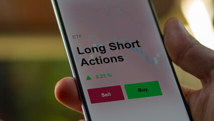 Un investisseur analyse un fonds etf long short actions sur un graphique. Un téléphone affiche le cours de l'ETF. Texte en français francais Long Short Actions