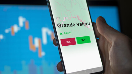 Un investisseur analyse un fonds etf grande valeur sur un graphique. Un téléphone affiche le cours de l'ETF largeCap, large cap. Texte en français, langue francaise. 