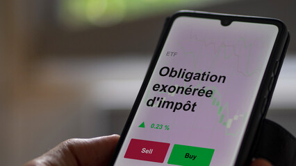 Un investisseur analyse un fonds etf obligation exonérée d'impôt sur un graphique. Un téléphone affiche le cours de l'ETF. Texte en français francais Obligation exonérée d'impôt