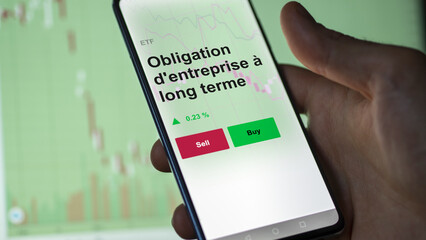 Un investisseur analyse un fonds etf obligation d'entreprise à long terme sur un graphique. Un téléphone affiche le cours de l'ETF. Texte en français francais Obligation d'entreprise à long terme