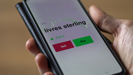 Un investisseur analyse un fonds etf livres sterling sur un graphique. Un téléphone affiche le cours de l'ETF. Texte en français francais livres sterling