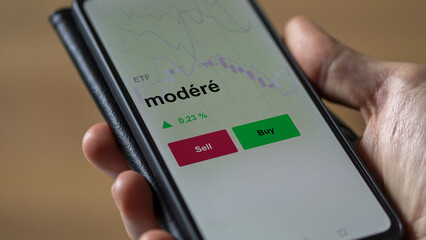 Un investisseur analyse un fonds etf modéré sur un graphique. Un téléphone affiche le cours de l'ETF. Texte en français francais modéré