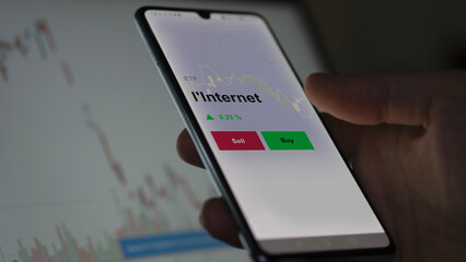 Un investisseur analyse un fonds etf l'internet sur un graphique. Un téléphone affiche le cours de l'ETF. Texte en français francais l'Internet