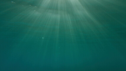 Sunrays penetrate through the surface of the water. Underwater light creates a beautiful veil, consisting of sunlight. range rays of the sun at sunset under the surface of the water. Red sea, Egypt