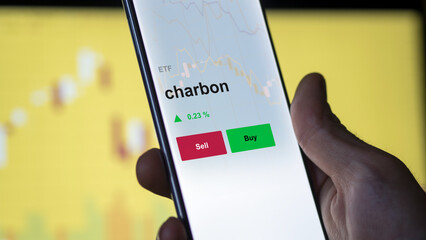 Un investisseur analyse un fonds etf charbon sur un graphique. Un téléphone affiche le cours de l'ETF. Texte en français francais charbon