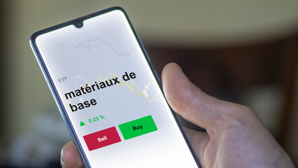 Un investisseur analyse un fonds etf matériaux de base sur un graphique. Un téléphone affiche le cours de l'ETF. Texte en français francais matériaux de base