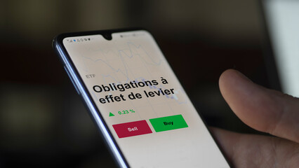 Un investisseur analyse un fonds etf obligations à effet de levier sur un graphique. Un téléphone affiche le cours de l'ETF. Texte en français francais Obligations à effet de levier
