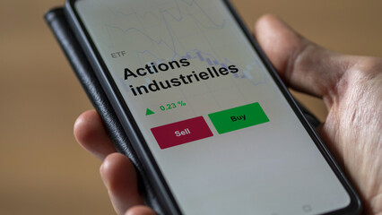 Un investisseur analyse un fonds etf actions industrielles sur un graphique. Un téléphone affiche le cours de l'ETF. Texte en français francais Actions industrielles