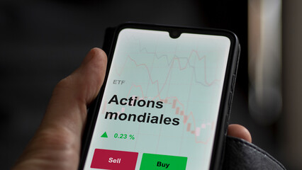 Un investisseur analyse un fonds etf actions mondiales sur un graphique. Un téléphone affiche le cours de l'ETF. Texte en français francais Actions mondiales