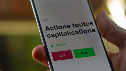 Un investisseur analyse un fonds etf actions toutes capitalisations sur un graphique. Un téléphone affiche le cours de l'ETF. Texte en français francais Actions toutes capitalisations