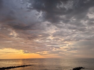 Deszczowe chmury podczas zachodu słońca nad morzem. 