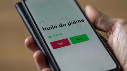 Un investisseur analyse un fonds etf huile de palme sur un graphique. Un téléphone affiche le cours de l'ETF. Texte en français francais huile de palme