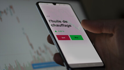 Un investisseur analyse un fonds etf l'huile de chauffage sur un graphique. Un téléphone affiche le cours de l'ETF. Texte en français francais l'huile de chauffage