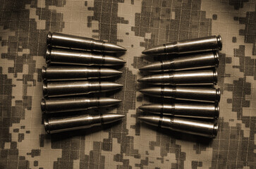 Rifle cartridges on a camouflage background. Top view. Sepia