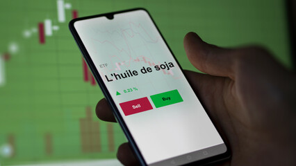 Un investisseur analyse un fonds etf l'huile de soja sur un graphique. Un téléphone affiche le cours de l'ETF. Texte en français francais L'huile de soja