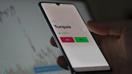 Un investisseur analyse un fonds etf turquie sur un graphique. Un téléphone affiche le cours de l'ETF. Texte en français francais Turquie
