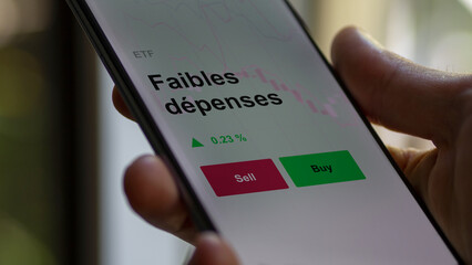 Un investisseur analyse un fonds etf faibles dépenses sur un graphique. Un téléphone affiche le...