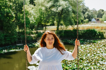 happy woman on swing above pond