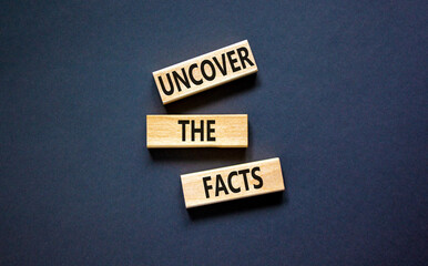 Uncover the facts symbol. Concept words Uncover the facts on wooden blocks on a beautiful black...