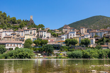 Vue estivale sur le village de Roquebrun depuis les berges de l'Orb